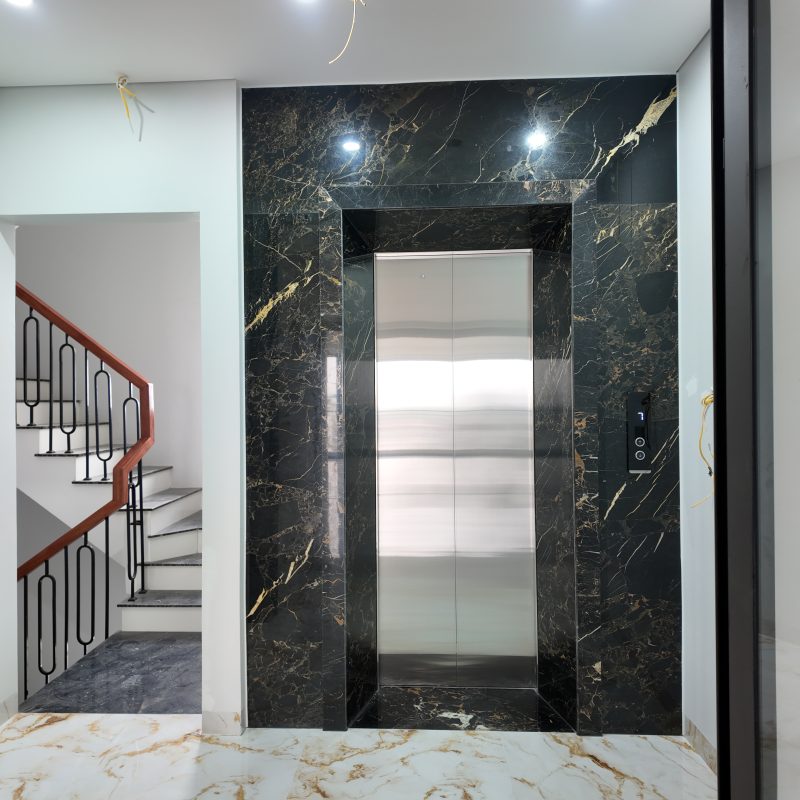 Cửa thang máy hố xây với phần ốp đá tại công trình